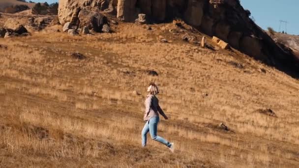 Dziewczyna biegnie wzdłuż jesiennego pola — Wideo stockowe