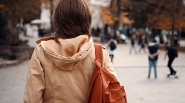 Kız sonbaharda parkta yürüyor