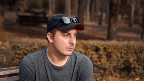 Депрессивный парень, сидящий один в парке после развода — стоковое видео