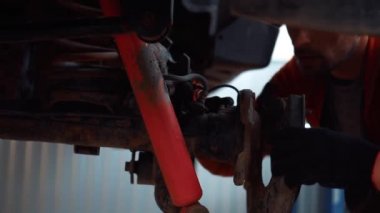 Araba tamirhanesindeki tamirciler araba tamiri yapıyor.