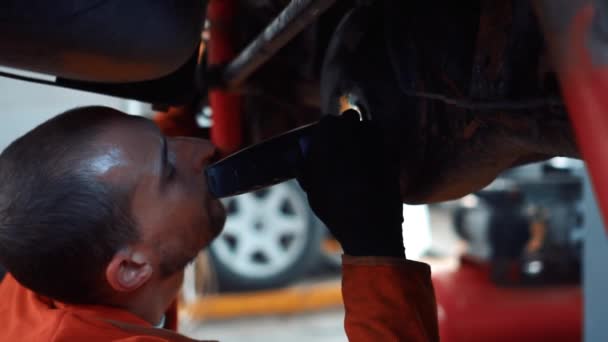 Mechanica in een auto reparatiewerkplaats doet auto reparatie — Stockvideo