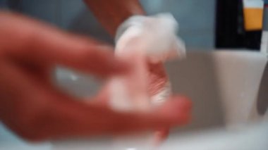 Kız yaralı bir kolu bandajlıyor.