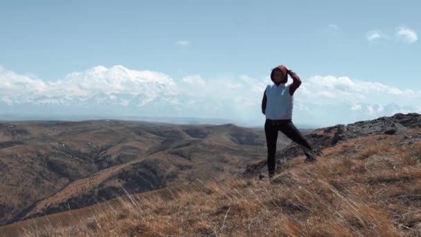 Dívka stojí na mýtině na pozadí spící sopky — Stock video