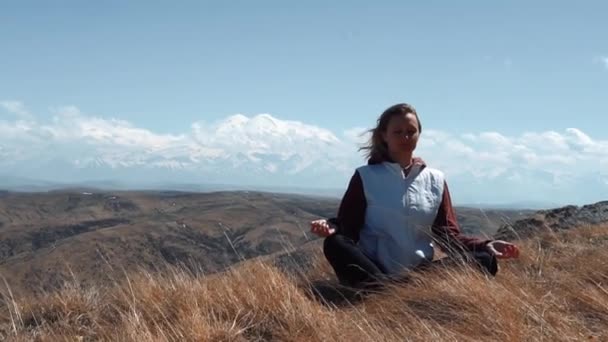 Chica medita en un claro sobre el fondo de un volcán dormido — Vídeos de Stock