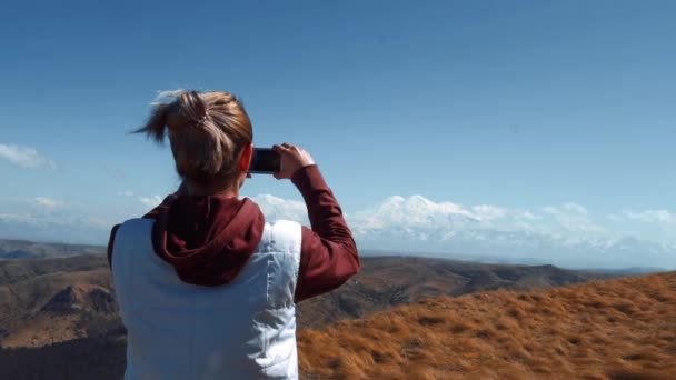 Девушка делает фото на телефон спящего вулкана — стоковое видео
