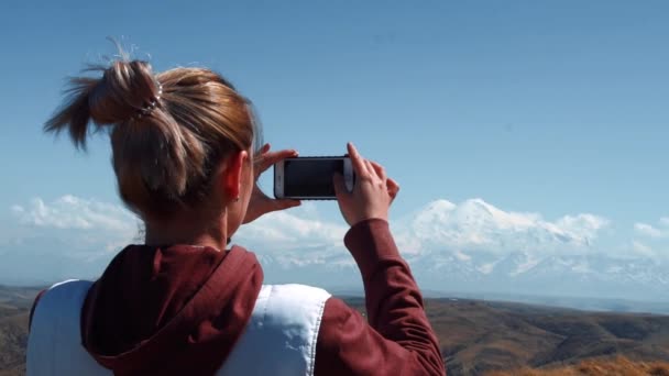 Meisje maakt een foto op de telefoon van een slapende vulkaan — Stockvideo