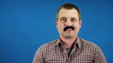 Adam sahte siyah bıyık yapıyor.