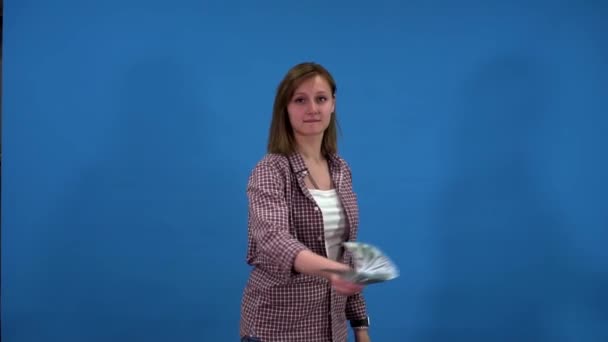 A lány egy doboz dollárt dob a kamerába. — Stock videók