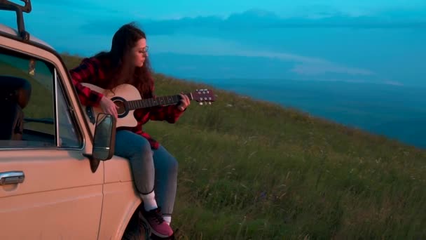 Menina tocando a guitarra ao pôr do sol — Vídeo de Stock