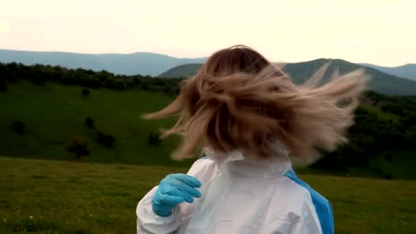 The girl takes off the protective biological suit and looks at the camera — Stock Video