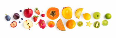 Meyve yapılmış yaratıcı düzeni. Düz yatıyordu. Erik, elma, çilek, yaban mersini, papaya, ananas, limon, portakal, limon, kivi, kavun, kayısı, pitaya ve beyaz arka plan üzerinde carambola.