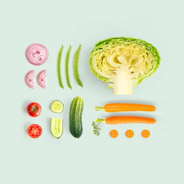 Creative layout made of cucumber, carrot, tomato, onion and cabbage and green beens. Flat lay. Food concept.