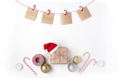 Hediye kırmızı şapka Noel Baba, altın ve gümüş toplar, mumlar, notlar clothespins, Doğum dilek ile üst görüntülemek beyaz arka plan Christmas yeni yıl