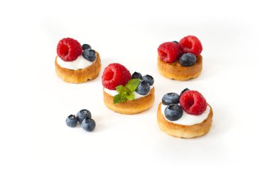 Yaban mersini, ahududu ve beyaz arka plan üzerinde taze nane ile Belçika Waffle