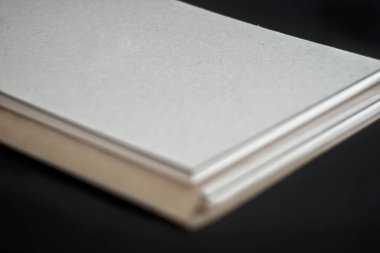 Bir sert karton kapak ve siyah arka plan üzerine bir zanaat zarf altlığında bahar karalama defteri. Yakın çekim.