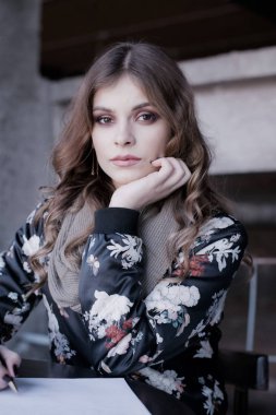 Güzel bir kız masada oturur, onun görünümü izleyiciye yöneliktir, o gebe, elinde kalem tutar ve sevgili bir mektup yazar.