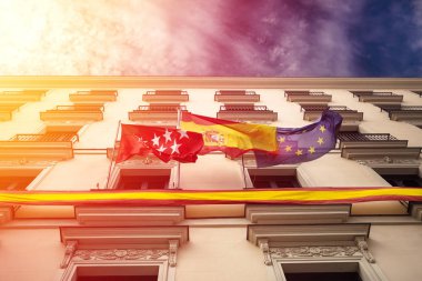 İspanya, Madrid ve binanın cephesinde Avrupa Birliği ile güzel dramatik gökyüzü güneş ışınları arka planda üzerinde bayrakları