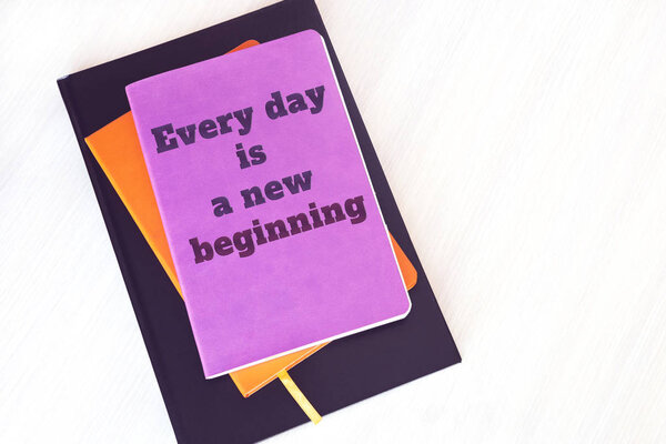 notebook, book or diary with motivational quote: Every day is a new beginning  