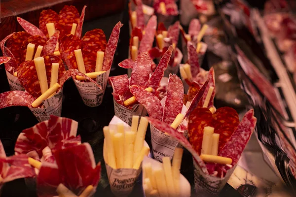 Traditionele Spaanse chorizo, Jamon en kaas hapjes voor afhaalmaaltijden op de beroemde markt in Barcelona, Catalonië, Spanje. 30 april 2019 — Stockfoto