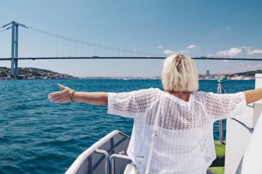 Büyük beyaz gemi veya yat güneş gözlüğü gülümseyen çekici kadın. Cruise, seyahat ve macera aktif emekli için. Arka planda güzel mavi deniz.