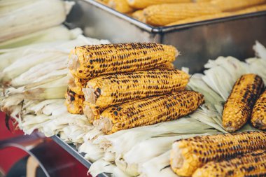 Şehir sokak gıda tezgahında sarı lezzetli ızgara mısır. Barbekü vejetaryen sokak yemekleri.