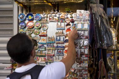 Gezgin bir buzdolabı mıknatıs seçer. Buzdolabı mıknatısları ile vitrin. Alışveriş ve seyahat konsepti. İstanbul, Türkiye'den hediyelik eşyalar. 2019-08-12