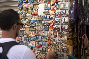 Gezgin bir buzdolabı mıknatıs seçer. Buzdolabı mıknatısları ile vitrin. Alışveriş ve seyahat konsepti. İstanbul, Türkiye'den hediyelik eşyalar. 2019-08-12