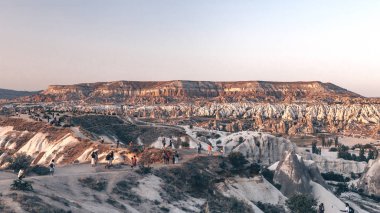 Kapadokya, Türkiye'deki dağların geniş açılı fotoğrafı. Ünlü taş tepeler. Turistler in üst günbatımı bakış açısı. Fotoğraf 16:9, 2019-08-13.
