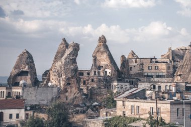 Kapadokya'da mağara evleri ve binalar. Kapı ve pencereleri olan taş zirveler. Gerçek mağaralarda konut