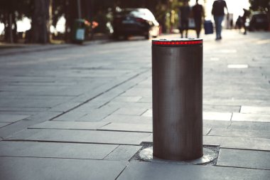 Aydınlatılmış geri çekilebilir otomatik trafik kazanı yaya bölgesini korur. Güvenlik kavramı. Arkaplanda bulanık insanlar.