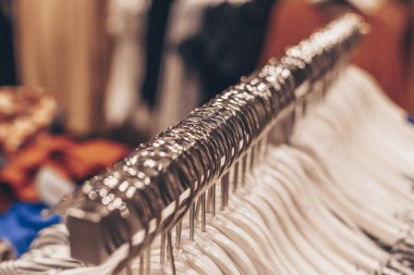 Dükkandaki askılarda bir sürü elbise askısı var. Alışveriş ve moda kavramı.
