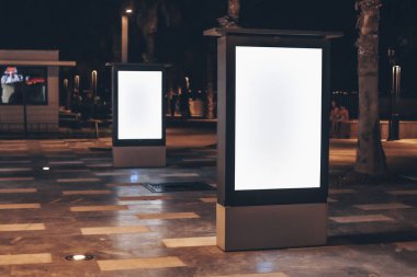 Fotokopi alanı olan sokak reklamcılığı şablonu. Gece sokağında beyaz beyaz ekranlı iki açık hava reklam pankartı..