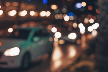 Arka planda bulanıklık, trafik sıkışıklığında araba ışıkları. Gece sokağındaki arabaların soyut geçmişi.
