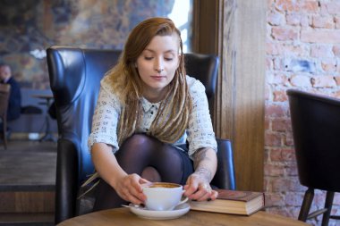 Güzel genç hipster serbest meslek sahibi bir kafede dinlendirici.
