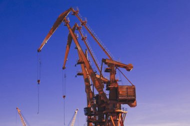 Mavi gökyüzü üzerinde mobil liman vinçler. Taşıma ve teknoloji konsepti