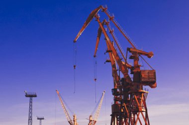 Mavi gökyüzü üzerinde mobil liman vinçler. Taşıma ve teknoloji konsepti