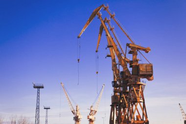 Mavi gökyüzü üzerinde mobil liman vinçler. Taşıma ve teknoloji konsepti