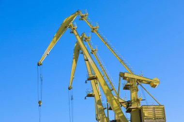 Mavi gökyüzü üzerinde mobil liman vinçler. Taşıma ve teknoloji konsepti