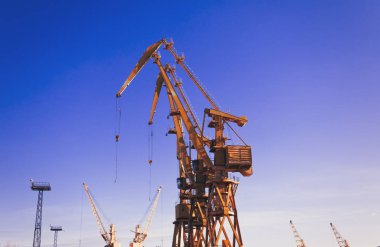 Mavi gökyüzü üzerinde mobil liman vinçler. Taşıma ve teknoloji konsepti