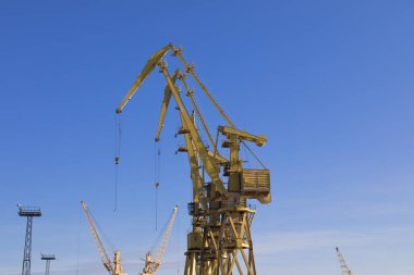 Mavi gökyüzü üzerinde mobil liman vinçler. Taşıma ve teknoloji konsepti