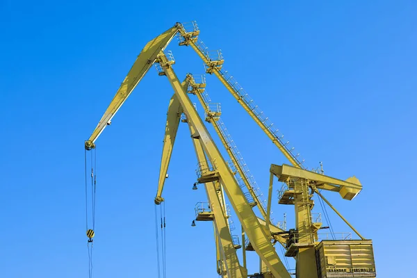 Mobile harbor cranes over blue sky. Transport and technology concept