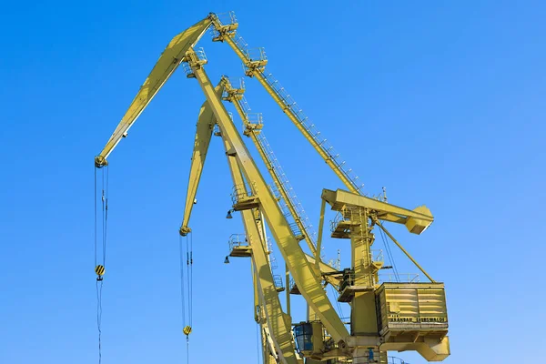 Mobile harbor cranes over blue sky. Transport and technology concept