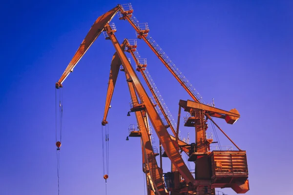 Mobile harbor cranes over blue sky. Transport and technology concept