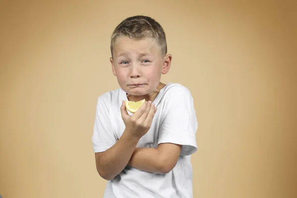 Little Blond Boy Biting Lemon Make Facial Expression — Stock Photo, Image