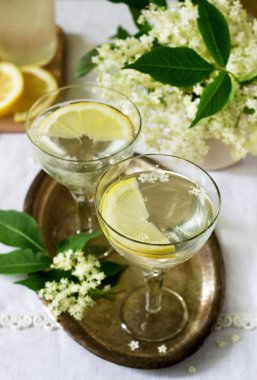 Limon ve elderflower soğuk bir içecek gözlük metal bir tepsi üzerinde şurubu. Rustik tarzı, seçici odak.