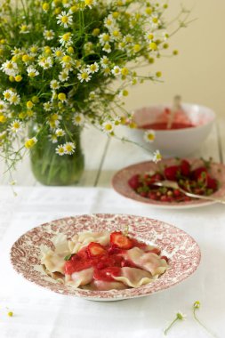 Bir ev yapımı kahvaltı veya öğle yemeği - hamur tatlısı veya çilek ve çilek sosu ile vareniki. Rustik tarzı, seçici odak.