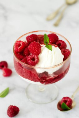 Pazar ile ahududu, çilek nane yaprakları ile dekore edilmiş ve bir klasik eski cam kadeh içinde görev yaptı. Seçici odak.