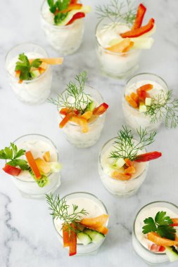 Bir bardak taze krema ve hafif bir arka plan üzerinde çeşitli sebze yemek saati. Seçici odak.