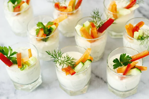 Bir bardak taze krema ve hafif bir arka plan üzerinde çeşitli sebze yemek saati. Seçici odak.