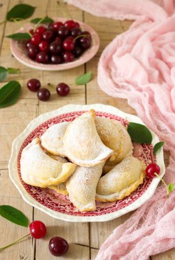 Turta ile kiraz, pudra şekeri ve meyveleri taze Kiraz ahşap yüzeye serpilir. Seçici odak.